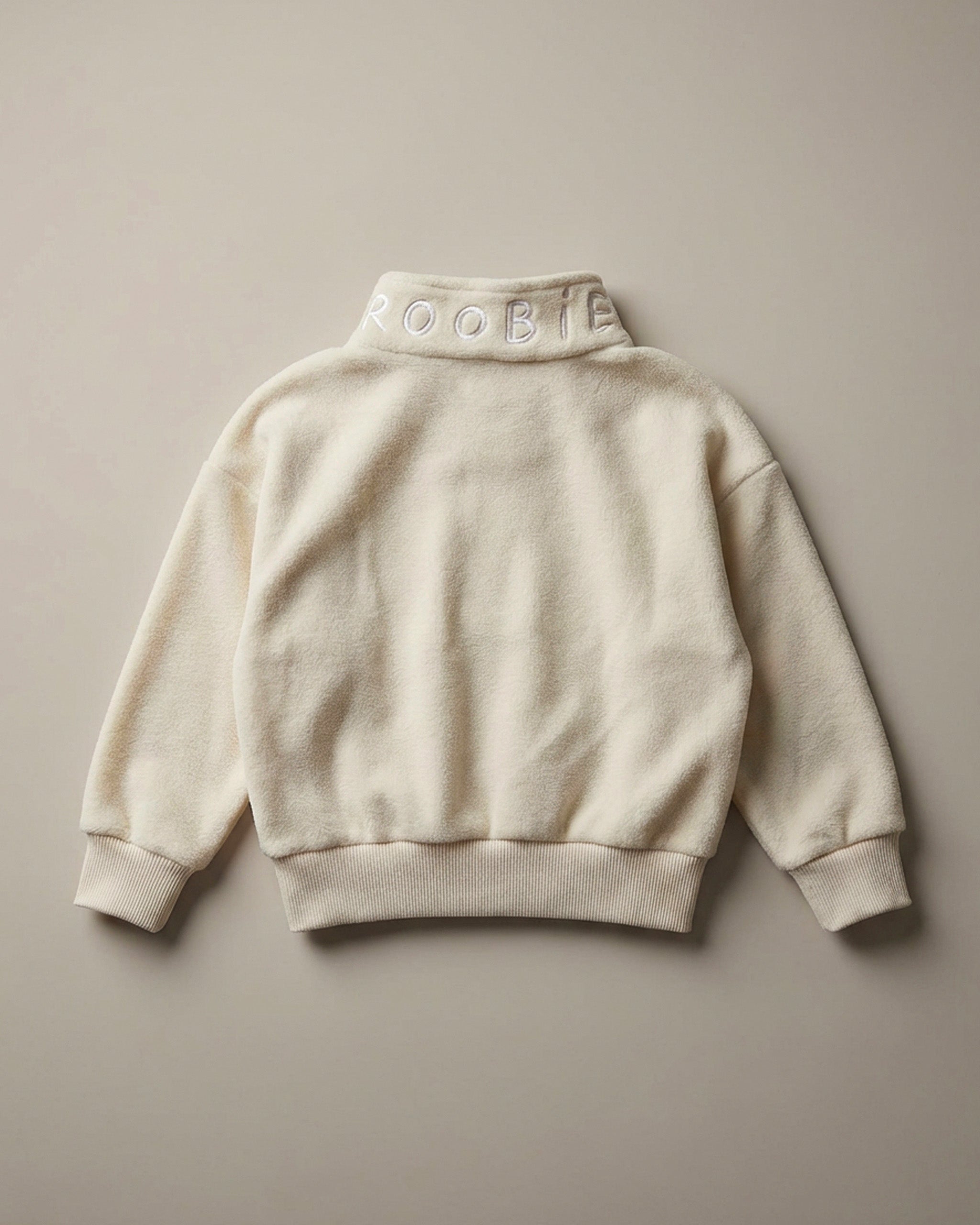 A cream ROOBiE oversized quarter-zip sweatshirt showing the quarter-zip neckline and oversized fit in a clean product image.