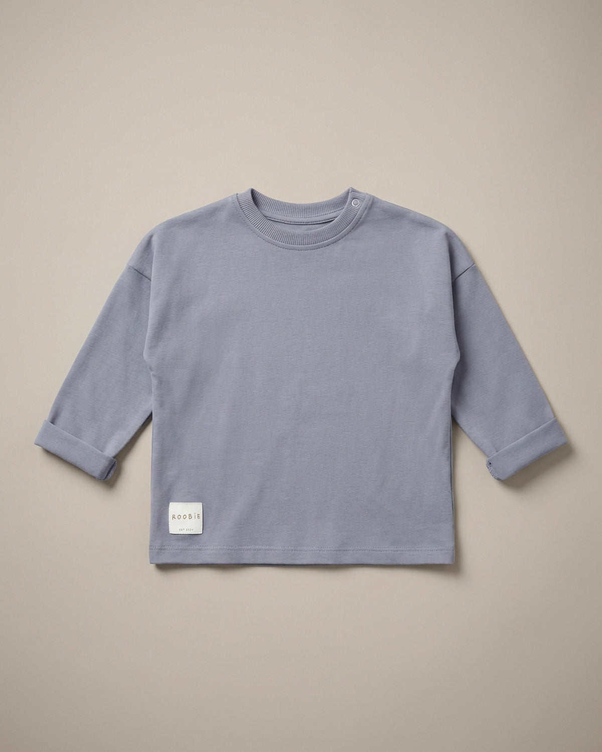 A light blue long sleeve t-shirt from ROOBiE, featuring an oversized fit, photographed against a neutral background.