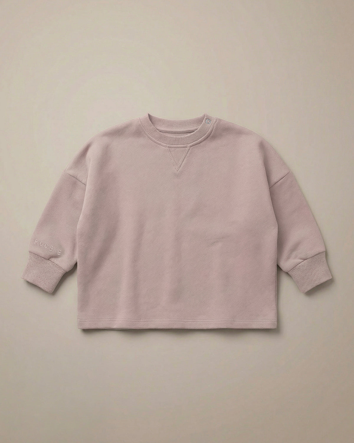 A soft pink jumper from ROOBiE, featuring oversized fit and soft fabric, photographed against a neutral background.