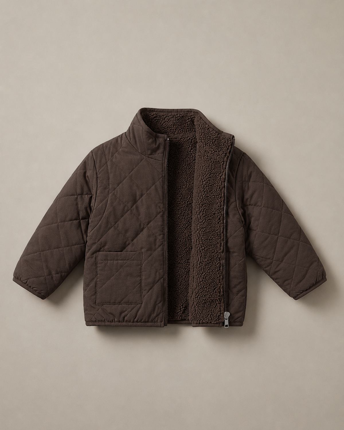 A dark brown 4-in-1 reversible quilted jacket with a soft, textured matching fleece lining, displayed flat against a solid beige background.