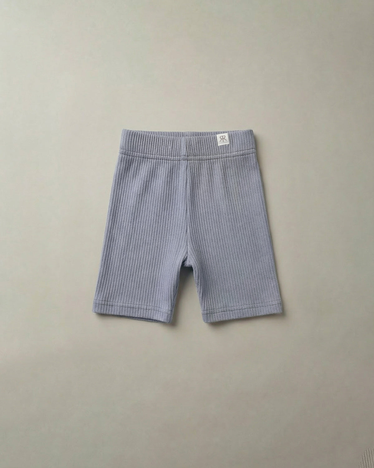 Blue ribbed cycling shorts on a beige background