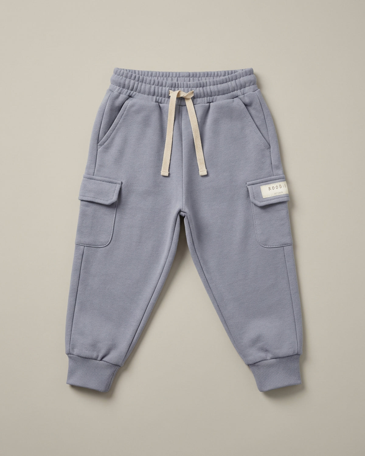 A light blue cargo trousers from ROOBiE, featuring cargo pockets and oversized fit, photographed against a neutral background.