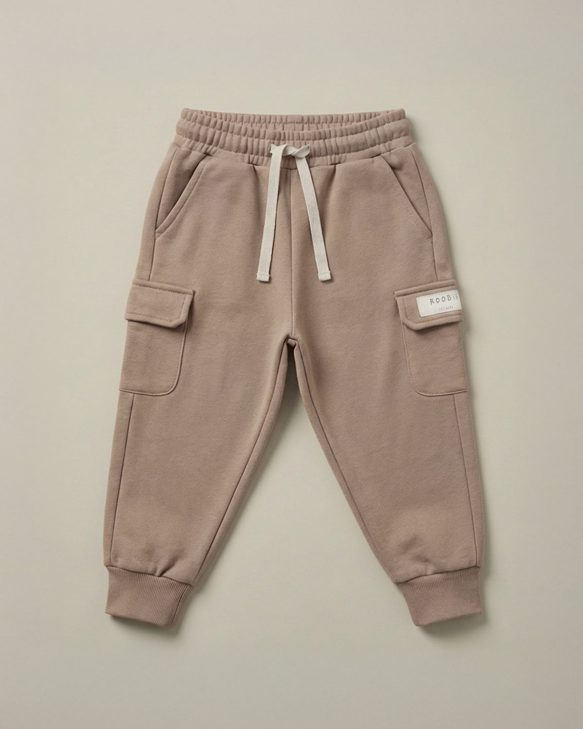 A warm brown cargo trousers from ROOBiE, featuring cargo pockets and oversized fit, photographed against a neutral background.