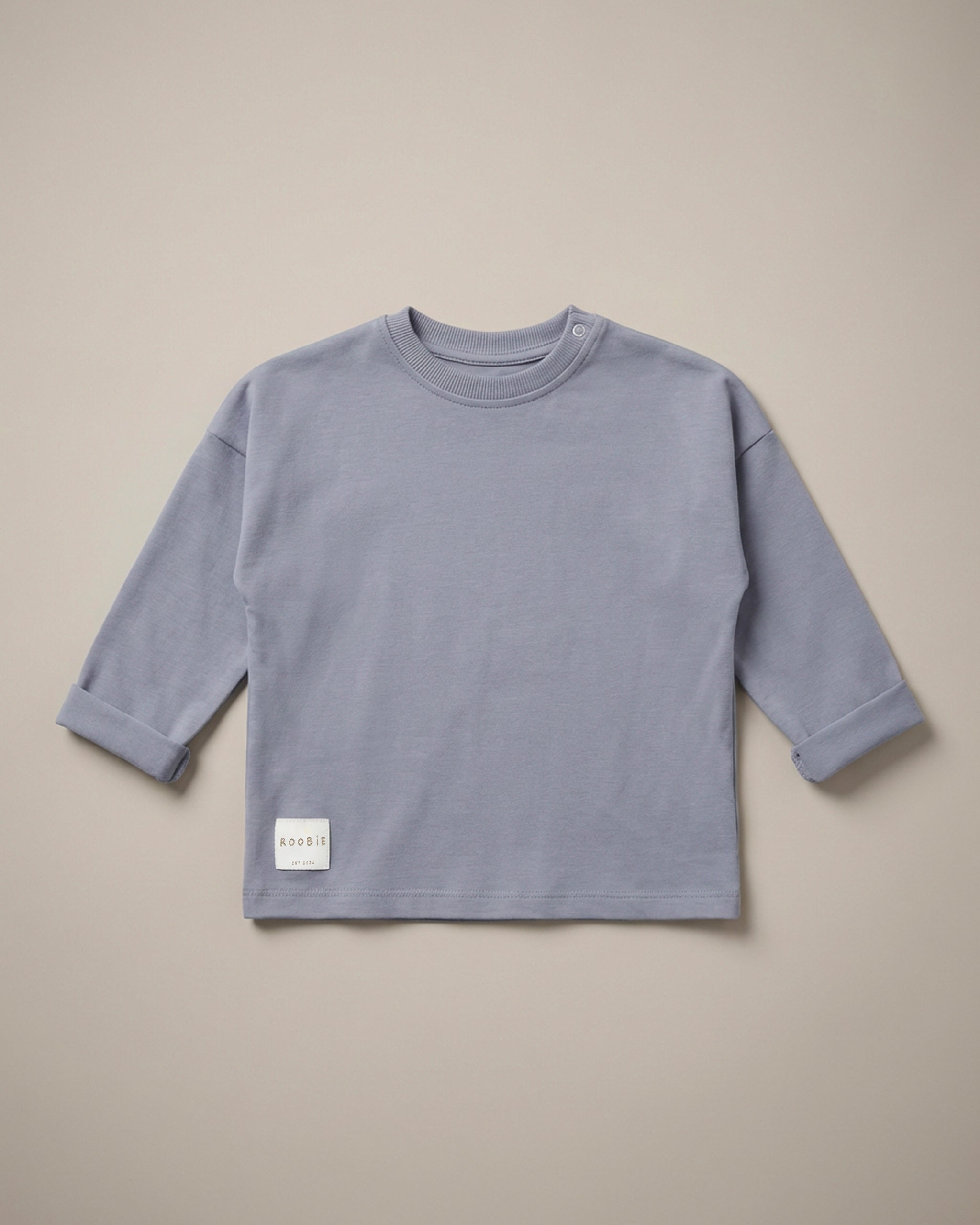 A light blue long sleeve t-shirt from ROOBiE, featuring an oversized fit, photographed against a neutral background.
