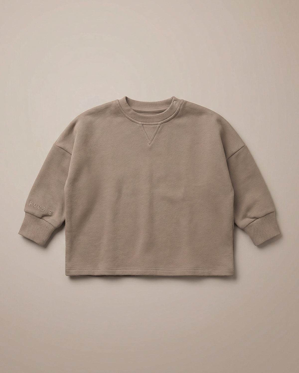 A warm brown jumper from ROOBiE, featuring oversized fit and soft fabric, photographed against a neutral background.