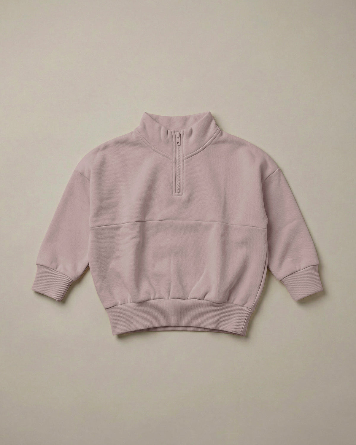 A soft pink quarter-zip sweatshirt from ROOBiE, featuring quarter-zip neckline and oversized fit, photographed against a neutral background.
