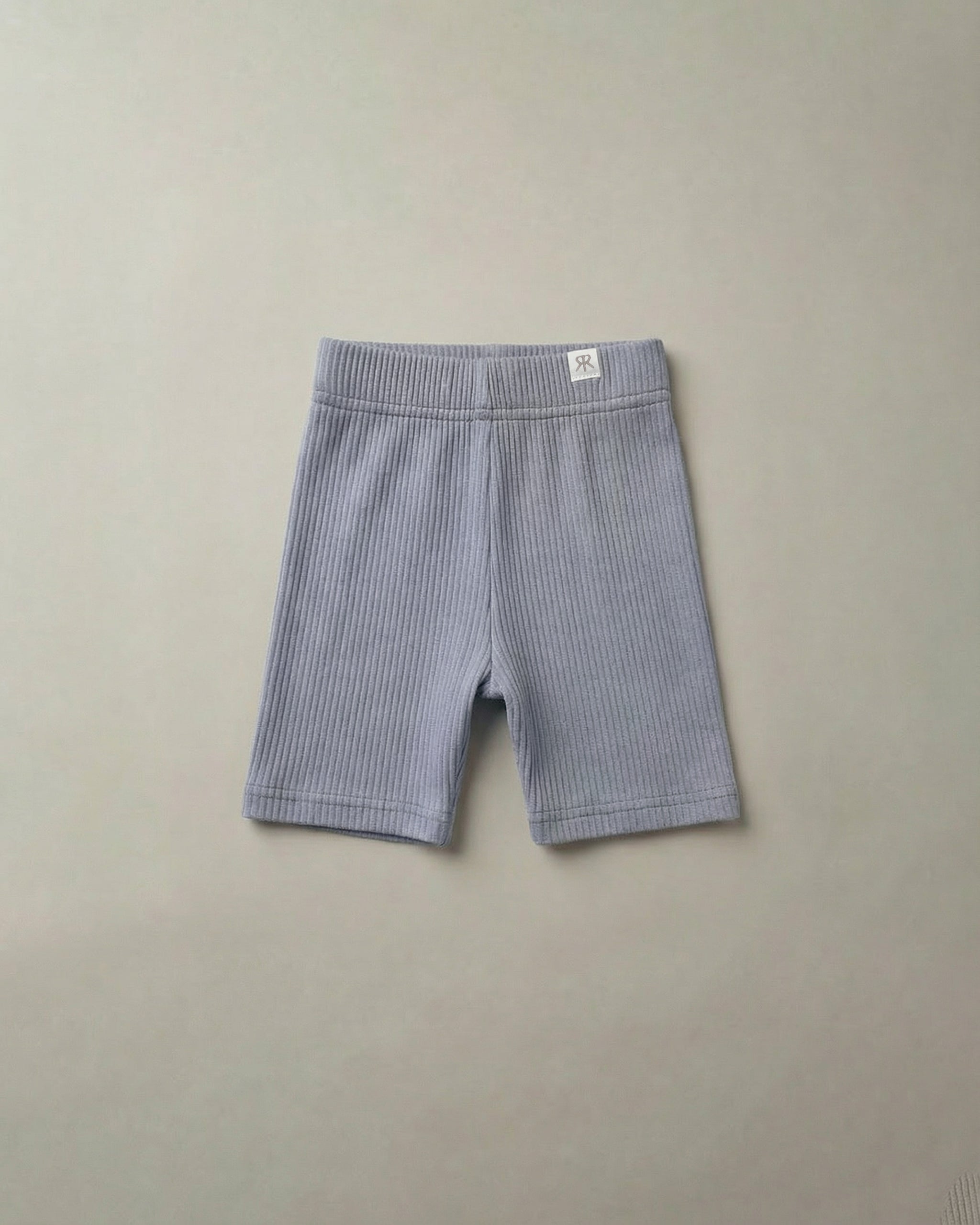 Blue ribbed cycling shorts on a beige background