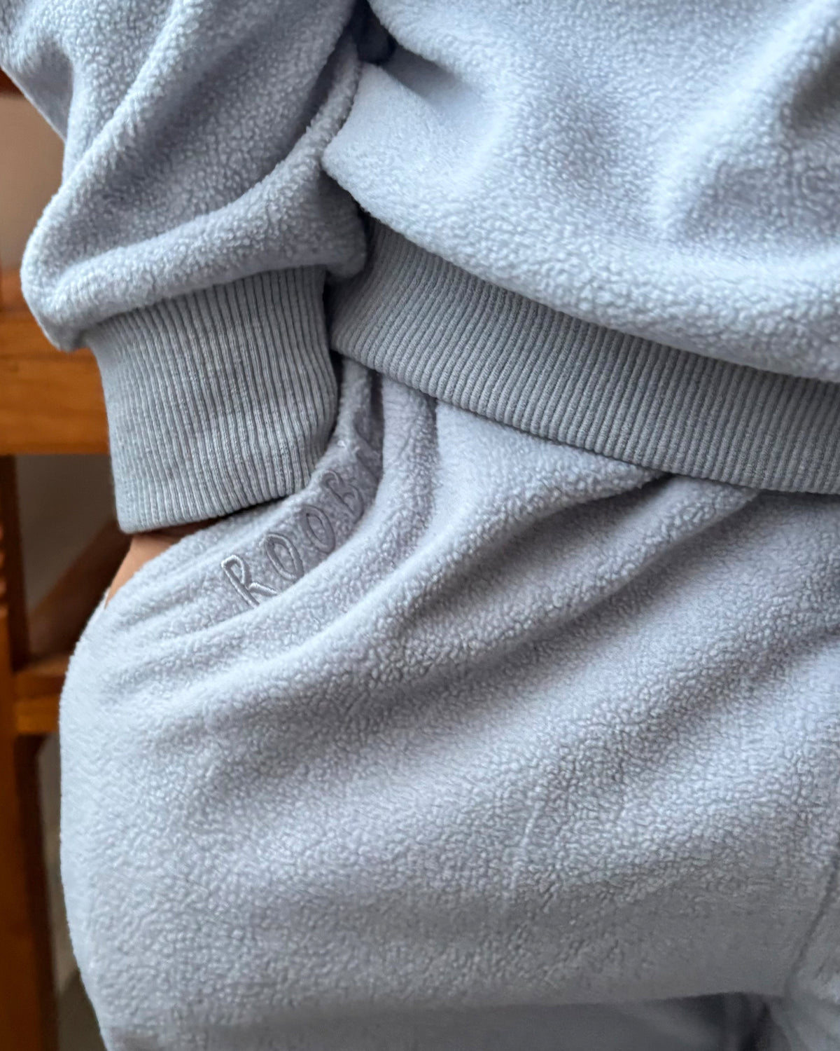 Light blue fleece wide leg joggers with a visible embroidered brand logo.